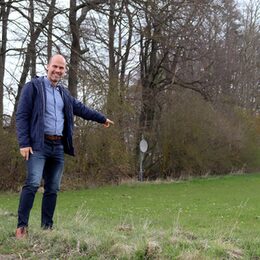 Markus Auel zeigt auf die Fläche neben dem Rinnener Sportplatzgelände, auf der ein Funkmast errichtet werden soll.